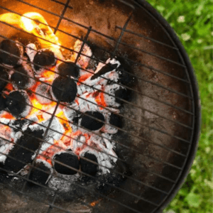 Parrilla con cortes de carne premium cocinándose frente al Lago Calima.