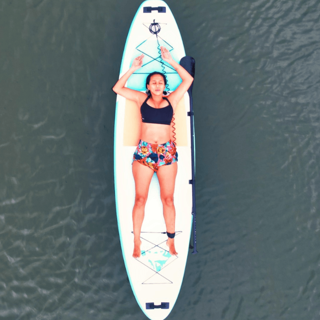 Persona practicando paddle surf en las aguas tranquilas del Lago Calima frente a Oasis.