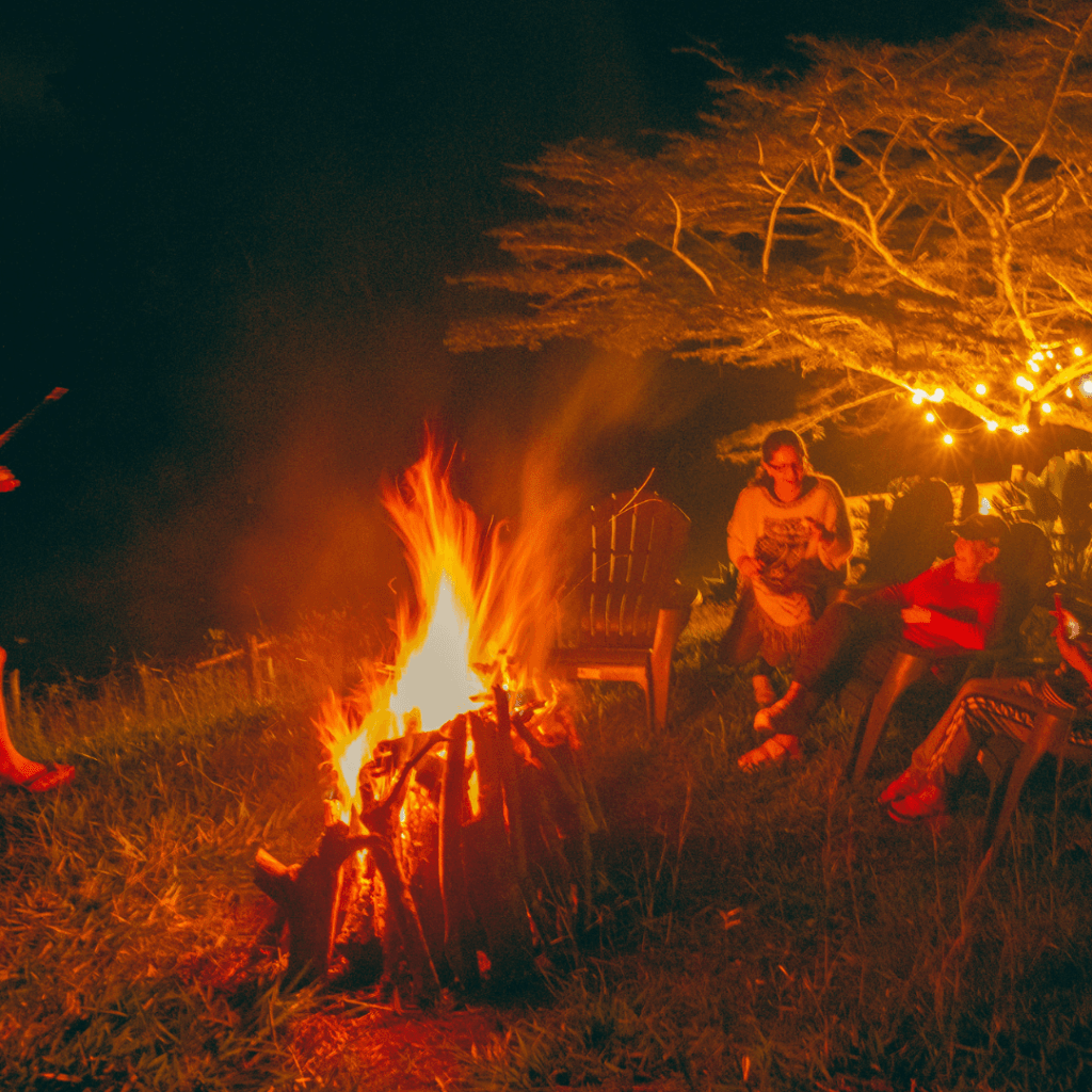 Huéspedes disfrutando de una fogata nocturna al aire libre en Oasis Lago Calima.