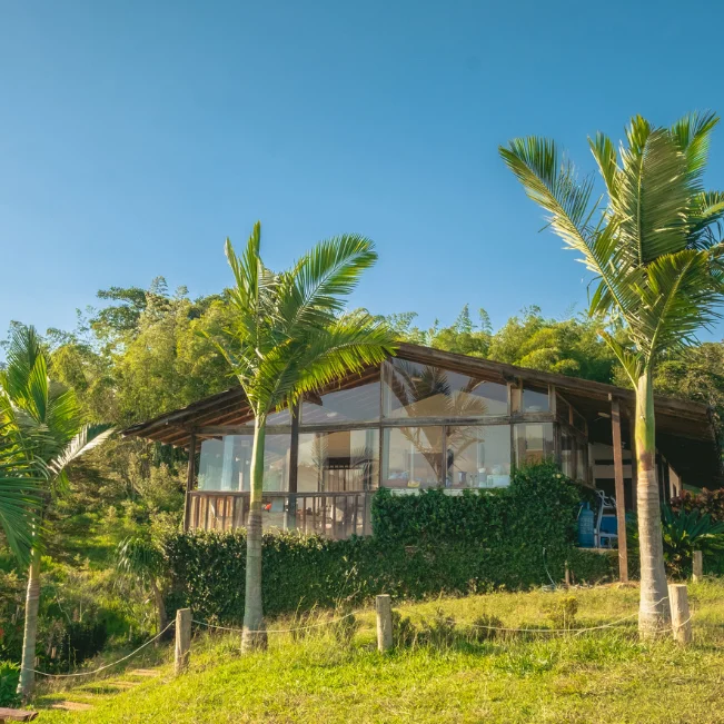 Cabaña de madera de lujo con ventanales grandes y muelle privado frente al Lago Calima, Colombia.